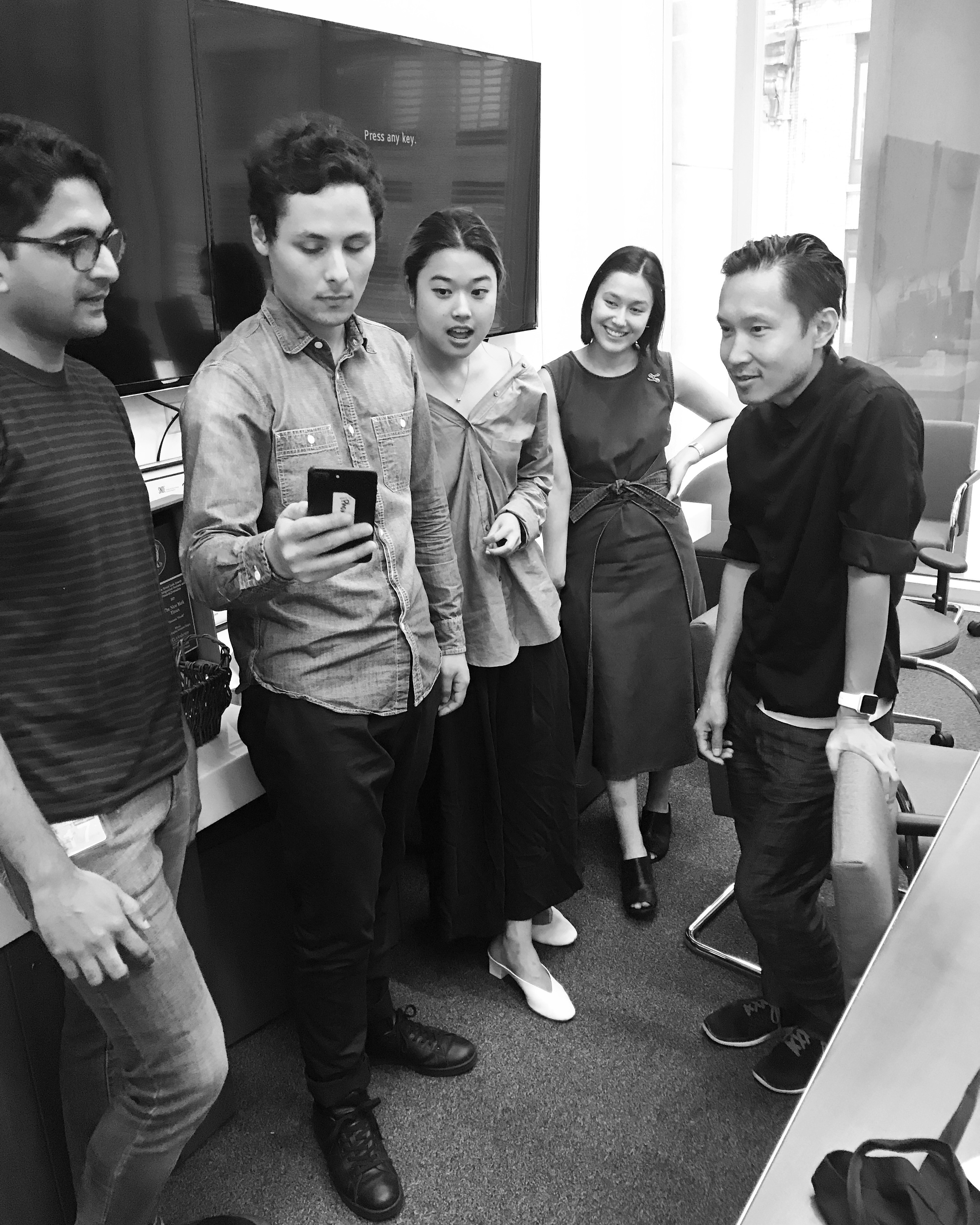 The New York Times AR team gathered around a phone, reviewing an early prototype